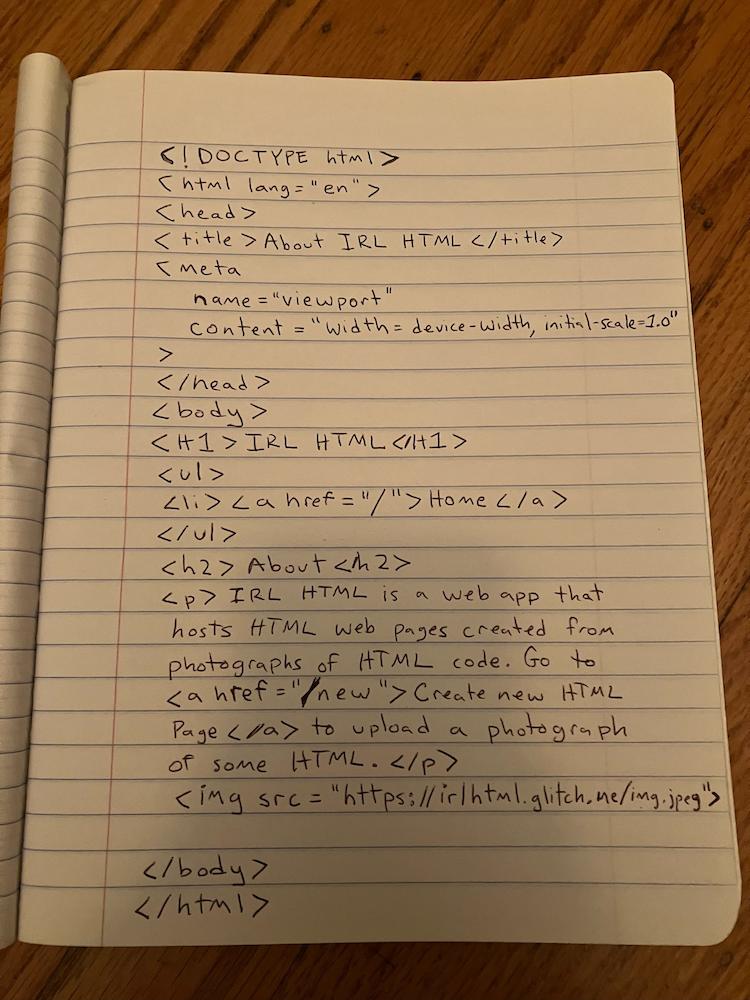 A photograph of a notebook with hand-written HTML code for an “About IRL HTML” website